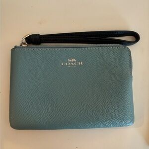 Light blue coach wristlet with dark blue strap.